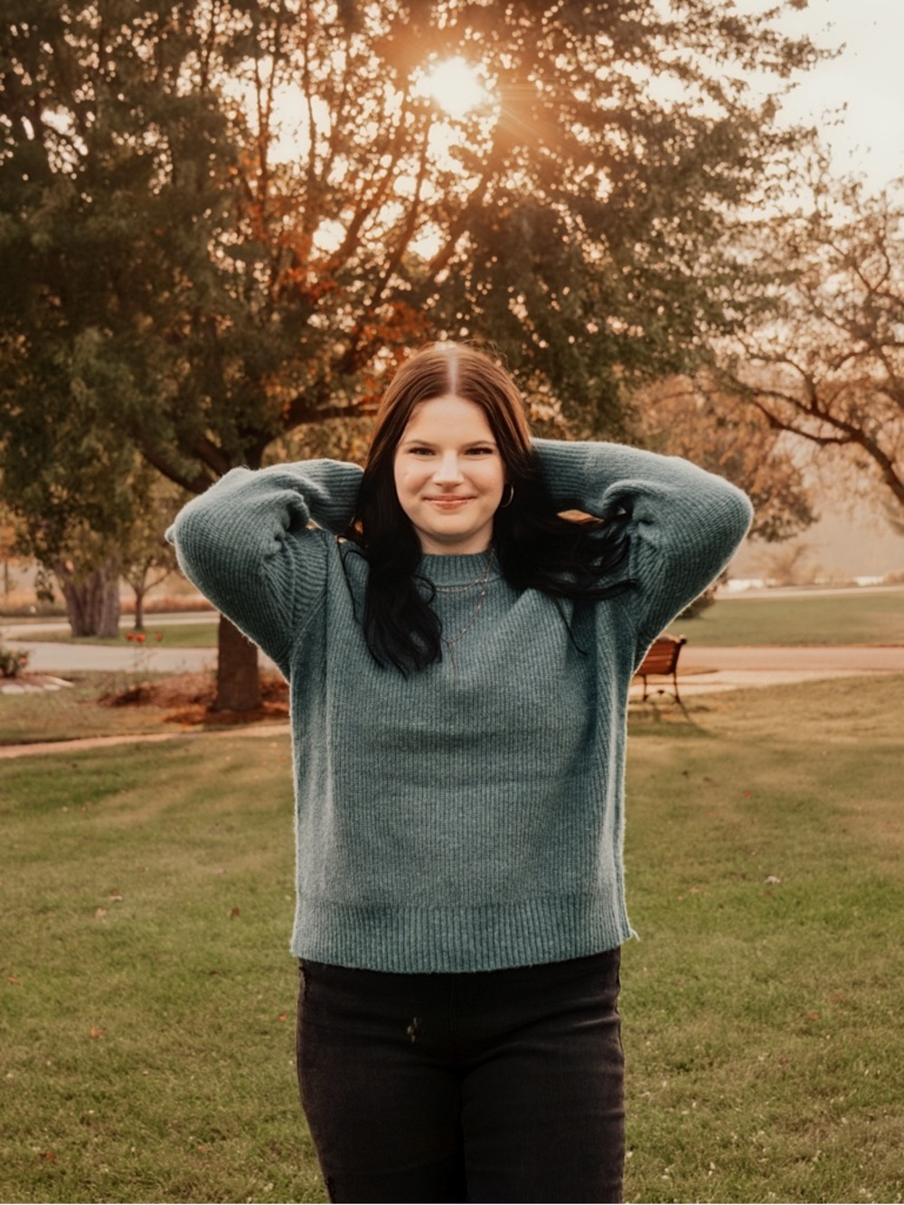Black slightly ripped flared a skinny jeans pared with dark blue sweater